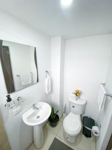 Habitación con baño compartido في بوغوتا: حمام ابيض مع مرحاض ومغسلة