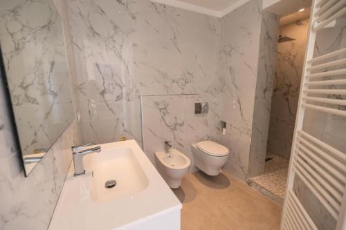 La salle de bains blanche est pourvue de toilettes et d'un lavabo. dans l'établissement Résidence Le Garavan Beach - 3 Pièces pour 5 Personnes 304, à Menton