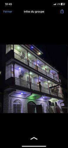 un edificio con luces azules y verdes. en Clientèle Hotel, en Cabo Haitiano