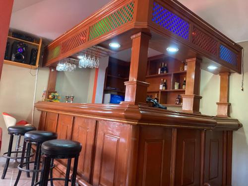 a wooden bar with stools in a room at Clientèle Hotel in Cap-Haïtien
