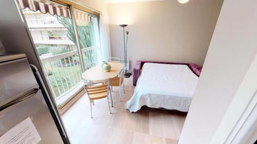 1 dormitorio con cama, mesa y ventana en Résidence Espace - Studio 774, en Menton