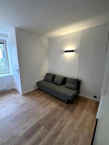 een woonkamer met een bank in de hoek van een kamer bij Maison fraichement rénové in Lille