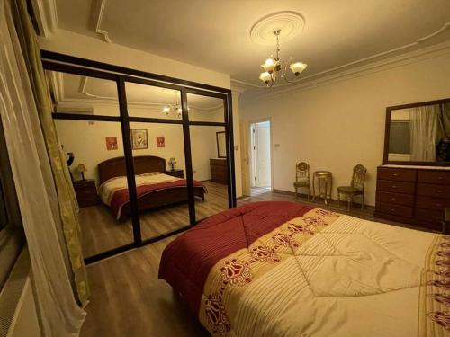 una camera con un grande letto e uno specchio di Comfortable family apt - 1002 ad Amman