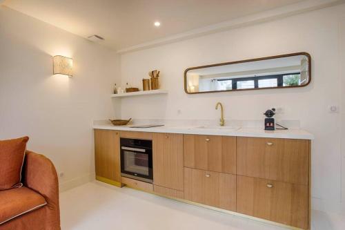 a kitchen with a sink and a mirror on the wall at HSH Blonville/Deauville : Magnifique maison avec jardin in Blonville-sur-Mer