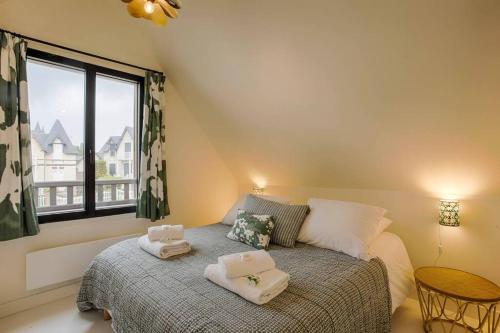 a bedroom with a bed with towels on it at HSH Blonville/Deauville : Magnifique maison avec jardin in Blonville-sur-Mer