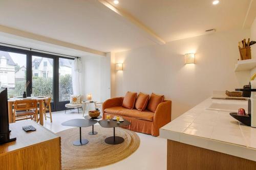 un salon avec un canapé et une table dans l'établissement HSH Blonville/Deauville : Magnifique maison avec jardin, à Blonville-sur-Mer