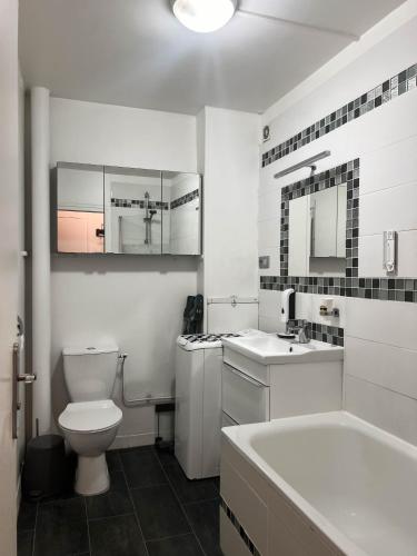 une salle de bain avec toilettes, lavabo et baignoire dans l'établissement La perle d'Alesia, à Paris