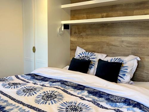 a bed with blue and white sheets and pillows at Studio Mari-Ange in Grimaud