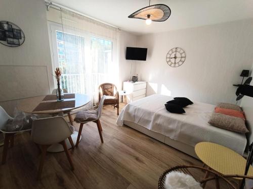 um quarto com uma cama, uma mesa e cadeiras em Résidence Montcalm C - Studio pour 2 Personnes 004 em Aix-les-Bains