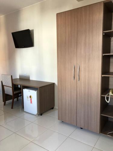 un bureau avec un bureau, une armoire et une table dans l'établissement HOTEL ELDORADO ECONOMIC, à Paracatu