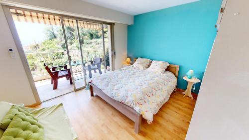 um quarto com uma cama com uma parede azul em Résidence Les Miradors - 3 Pièces pour 6 Personnes 524 em Menton