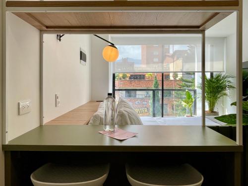 a dining room with a table and two stools at Oliving by Wynwood House in Medellín