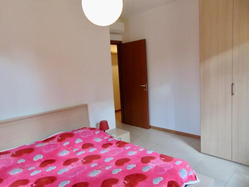 una camera con un letto con una copertina rosa di SE043 - Senigallia, nuovo trilocale accessoriato a 100 mt dal mare a Senigallia