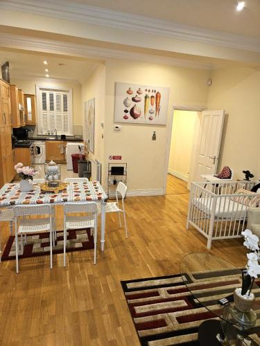 a living room with a table and a kitchen at LONDON HEATHROW GLAMOUR MANSION HOUSE in Uxbridge