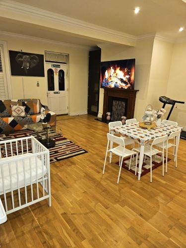 a living room with a table and a fireplace at LONDON HEATHROW GLAMOUR MANSION HOUSE in Uxbridge