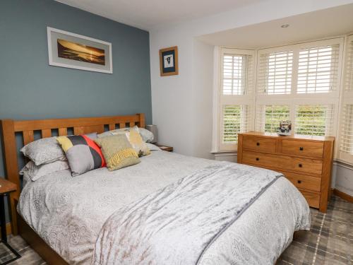 - une chambre avec un lit, une commode et des fenêtres dans l'établissement Dolwern, à Newport