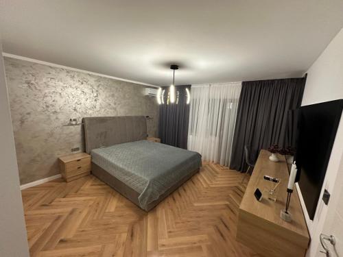 um quarto com uma cama e piso em madeira em Traian Deluxe em Drobeta-Turnu Severin