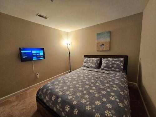 a bedroom with a bed and a flat screen tv at Lovely furnished apartment in Owings Mills