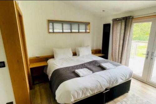 a bedroom with a large bed and a window at Lush Lodge 