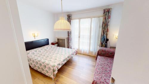 een slaapkamer met een bed, een tafel en een stoel bij Résidence Saint Christophe - 3 Pièces pour 4 Personnes 004 in Menton