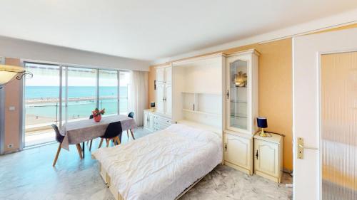 Schlafzimmer mit einem Bett und einem Schreibtisch mit Meerblick in der Unterkunft Résidence Nereides - Studio pour 2 Personnes 184 in Roquebrune-Cap-Martin