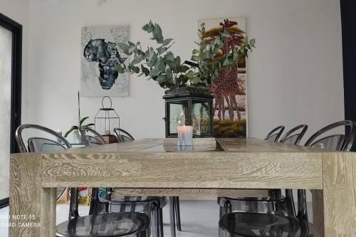 una mesa de comedor con sillas y un jarrón con una planta en Loue maison d'architecte 300m du sillon - 8 couchages- jacuzzi en Saint-Malo