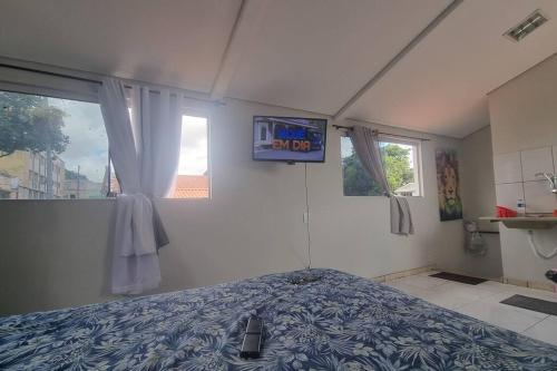 sypialnia z łóżkiem w pokoju z oknami w obiekcie Studio 3 min Centro de BH w mieście Belo Horizonte