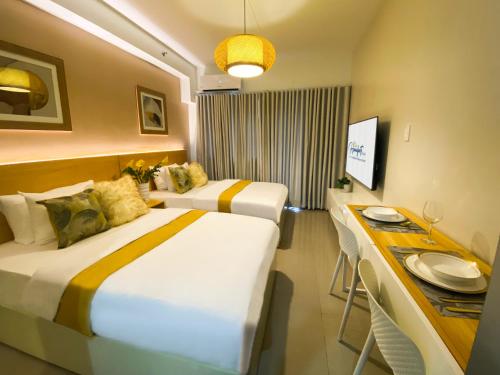 a hotel room with two beds and a table at Homefort at Shore Residences in Manila