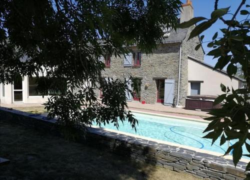 una casa y una piscina frente a una casa en gite de la Marzelle, en Saint-Sulpice-des-Landes
