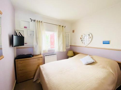 une petite chambre avec un lit et une télévision dans l'établissement Green Village - Deux pièces vue sur le golf 4 pers avec Clim MAE-0734, à La Grande Motte