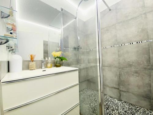 une salle de bain avec une douche en verre avec un lavabo dans l'établissement Green Village - Deux pièces vue sur le golf 4 pers avec Clim MAE-0734, à La Grande Motte