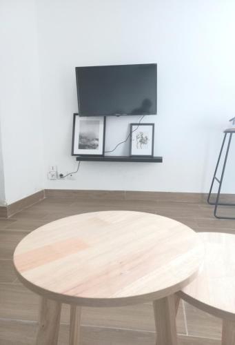 Cette chambre dispose d'une table en bois et d'une télévision murale. dans l'établissement Le Cosy de Vendargues, à Vendargues