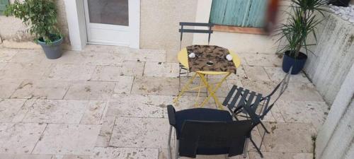 une table et des chaises assises sur une terrasse en pierre dans l'établissement Le Cosy de Vendargues, à Vendargues