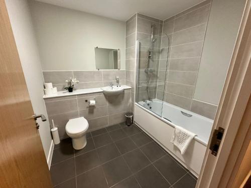 La salle de bains est pourvue de toilettes, d'un lavabo et d'une douche. dans l'établissement Adelphi Wharf Apartments by Beehosting, à Manchester