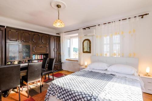 Schlafzimmer mit einem Bett und einem Schreibtisch mit Stühlen in der Unterkunft Apartment Ivona in Dubrovnik