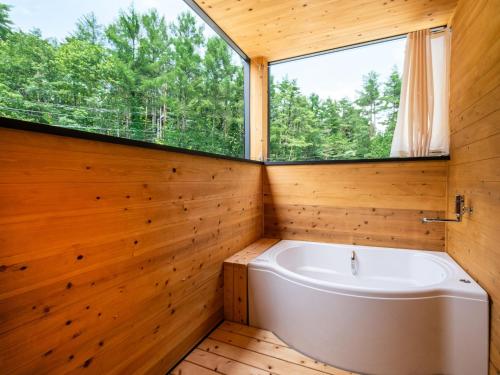 baño con bañera y ventana en FJ Forest - Vacation STAY 37809v, en Fujikawaguchiko