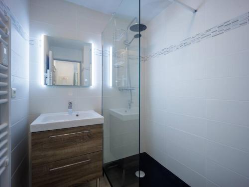 La salle de bains blanche est pourvue d'un lavabo et d'un miroir. dans l'établissement Appartement Peyragudes, 2 pièces, 6 personnes - FR-1-695-4, à Germ