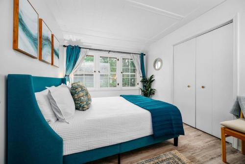 um quarto com uma cama azul e branca e uma janela em Bay Breeze 6BR Home Downtown Beaches Wineries Bay em Traverse City