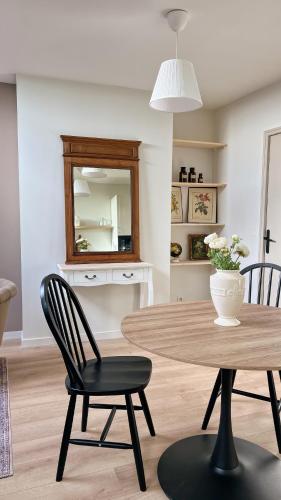 a dining room with a table and chairs and a mirror at The Brick House - Appartement Renoir in La Roche-Guyon