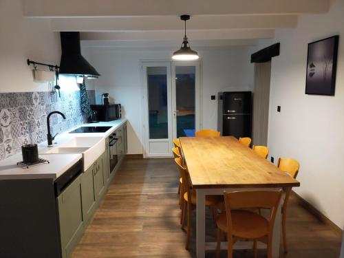 cocina con mesa de madera y comedor en La Longère de Fréd et Line, en La Garnache