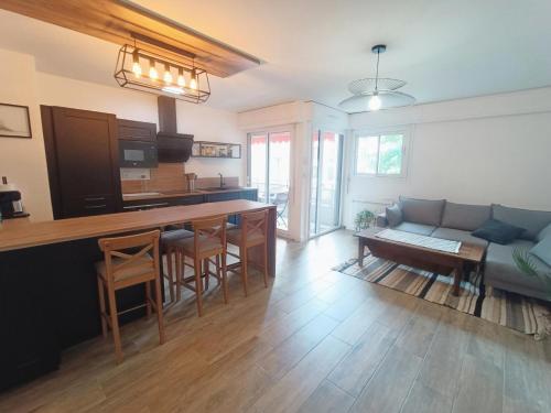 une cuisine et un salon avec un canapé et une table dans l'établissement Résidence Le Chateau Durieux 1 - Belles prestations pour ce joli 2 pièces ! MAE-1824, à Aix-les-Bains