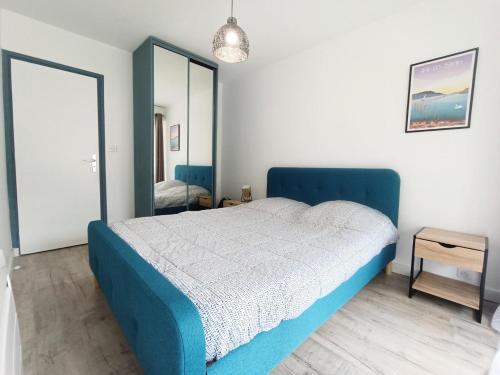 une chambre avec un lit bleu et un miroir dans l'établissement Résidence Le Chateau Durieux 1 - Belles prestations pour ce joli 2 pièces ! MAE-1824, à Aix-les-Bains