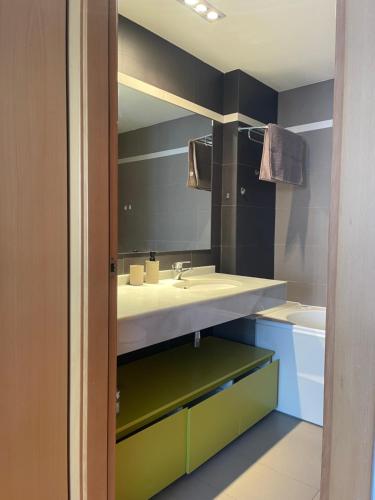 ein Bad mit einem Waschbecken und einem Spiegel in der Unterkunft Diagonal Mar in Barcelona