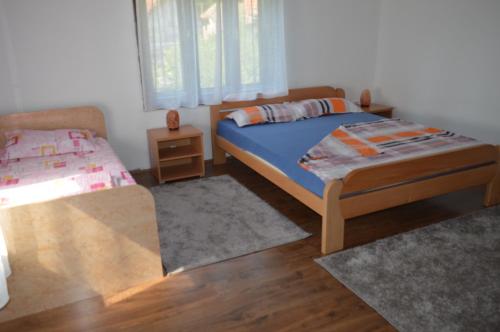 a bedroom with a bed and a couch and a bed and window at Kuca Rancic in Pirot