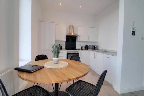 a kitchen with a table with chairs and a laptop on it at Sound of the Sea - Ilfracombe in Ilfracombe