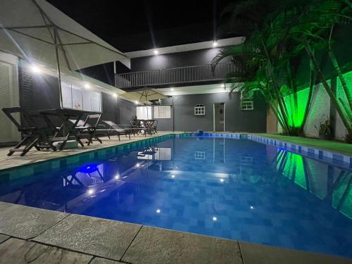 uma grande piscina à noite com luzes acesas em POUSADA BRISA MAR em Ubatuba