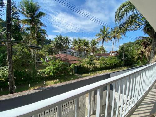 uma varanda com vista para uma rua e palmeiras em POUSADA BRISA MAR em Ubatuba