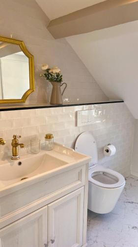 une salle de bain blanche avec un lavabo et des toilettes dans l'établissement The Brick House - Appartement Renoir, à La Roche-Guyon