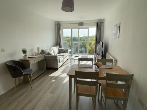 a living room with a table and a couch at Balcony Apartment - Views Of Etihad Stadium - Near CoOp Live Arena in Manchester