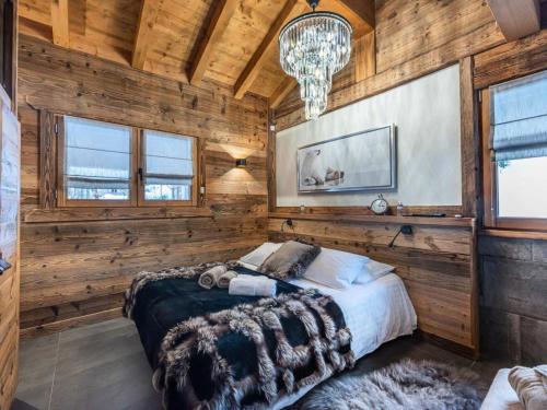 um quarto com uma cama grande numa parede de madeira em Chaletb - Chalets pour 10 Personnes 991 em Villard-sur-Doron